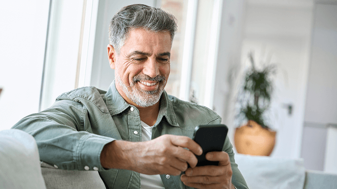Patient smiling reading a care update received in their multilingual patient portal.