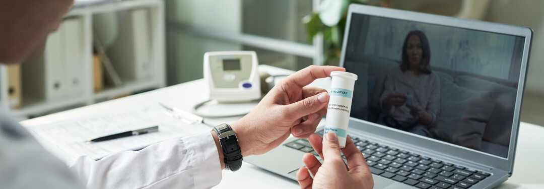 A physician displays a medicine bottle representing real-time prescription benefit solutions.