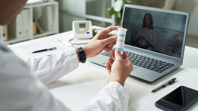  A physician displays a medicine bottle representing real-time prescription benefit solutions.