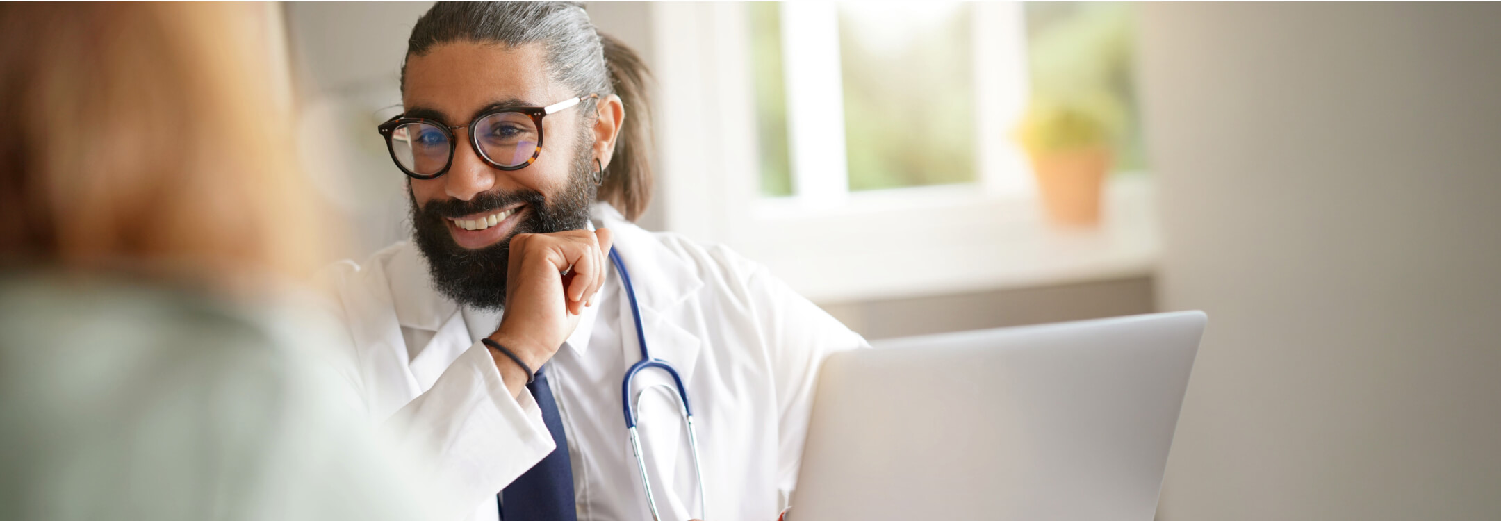  A healthcare professional smiling while discussing value-based care with a patient using athenaOne.