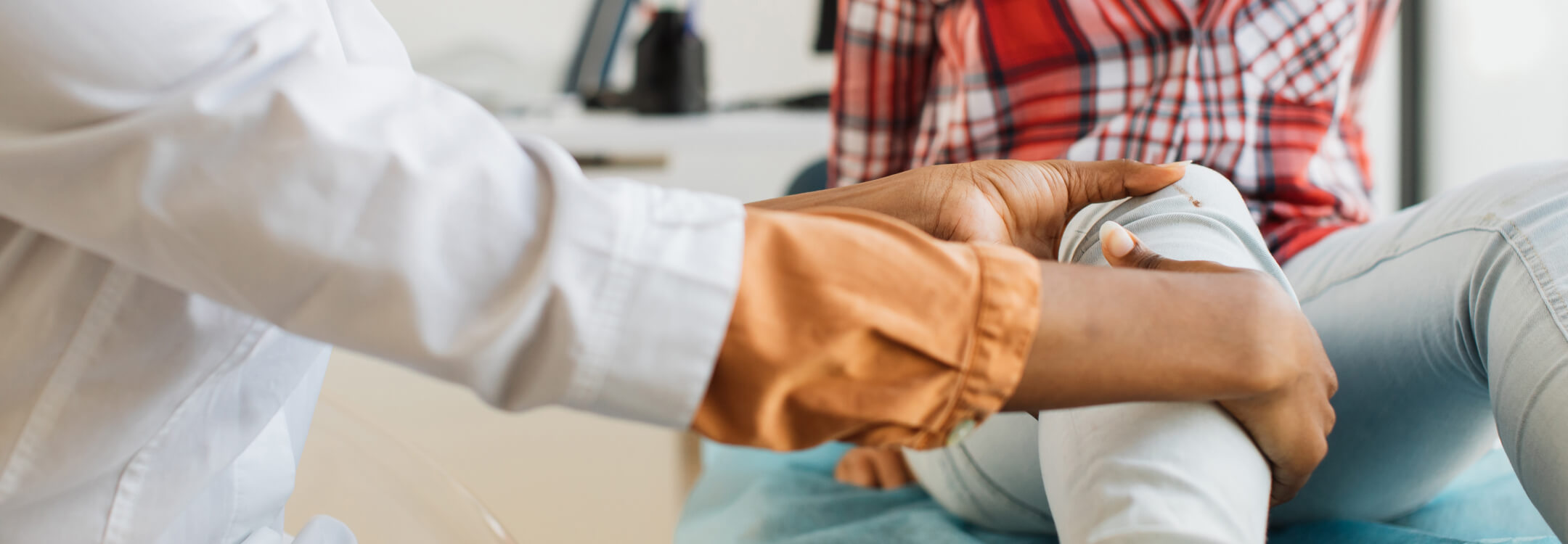 A physician assesses a patient's knee while addressing the increase in youth sports-related injuries.