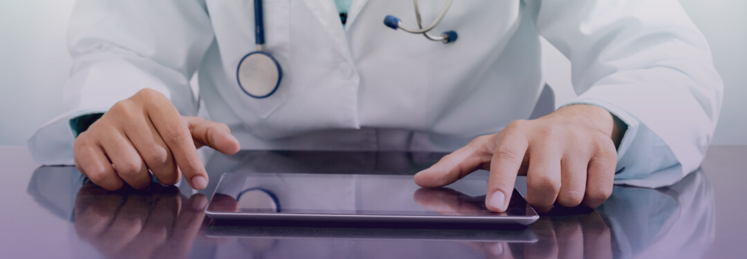 A healthcare professional uses a tablet to access medical data in their office.
