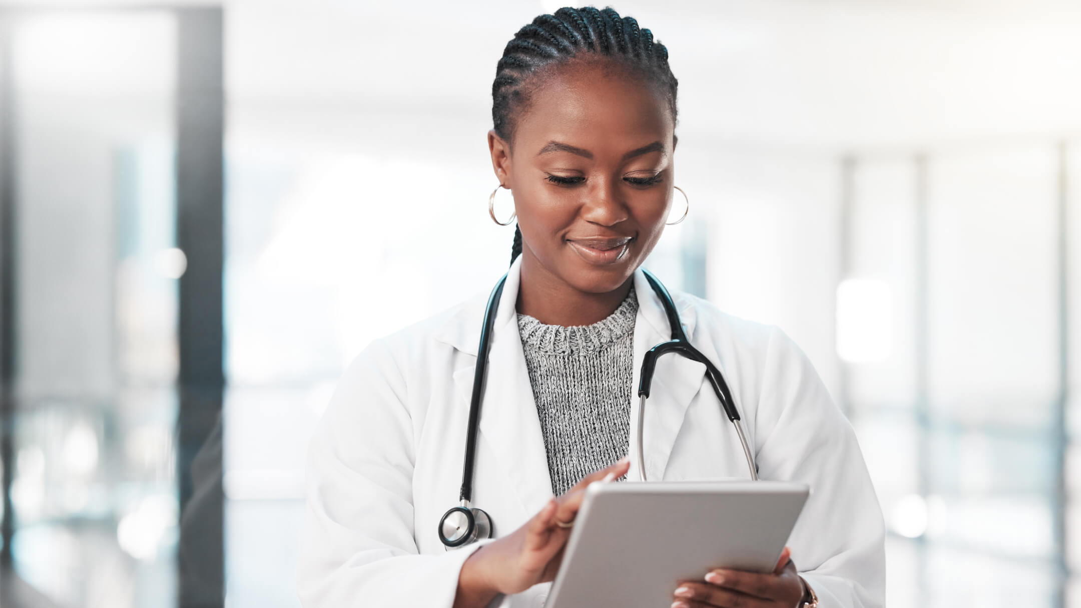 A doctor is holding a tablet, which reflects the diverse views on AI in healthcare research in the U.S.