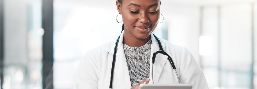 A doctor is holding a tablet, which reflects the diverse views on AI in healthcare research in the U.S.