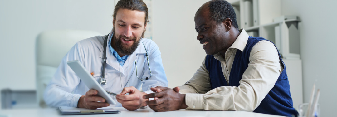 male physician reviewing electronic health record with medicare patient
