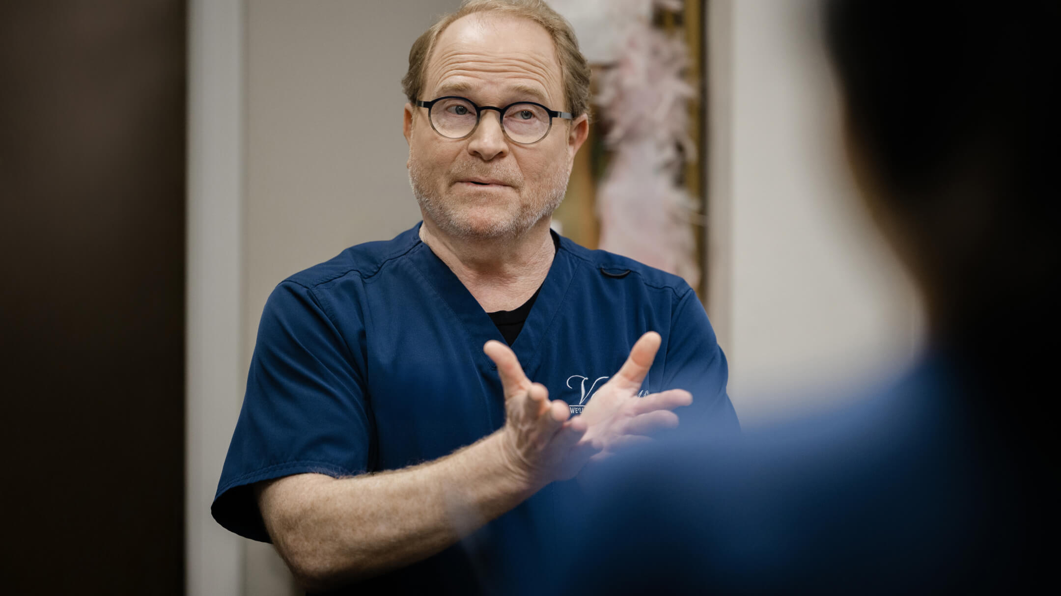 A physician engages in conversation, addressing the impact of policy uncertainty on clinical practices.