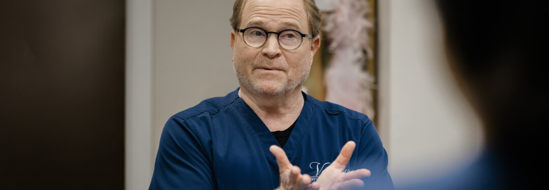 A physician engages in conversation, addressing the impact of policy uncertainty on clinical practices.