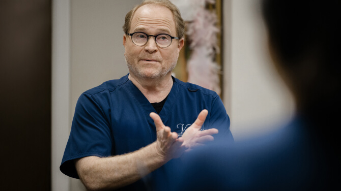 A physician engages in conversation, addressing the impact of policy uncertainty on clinical practices.