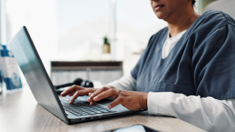 Doctor typing notes to document a patient encounter in the EHR.
