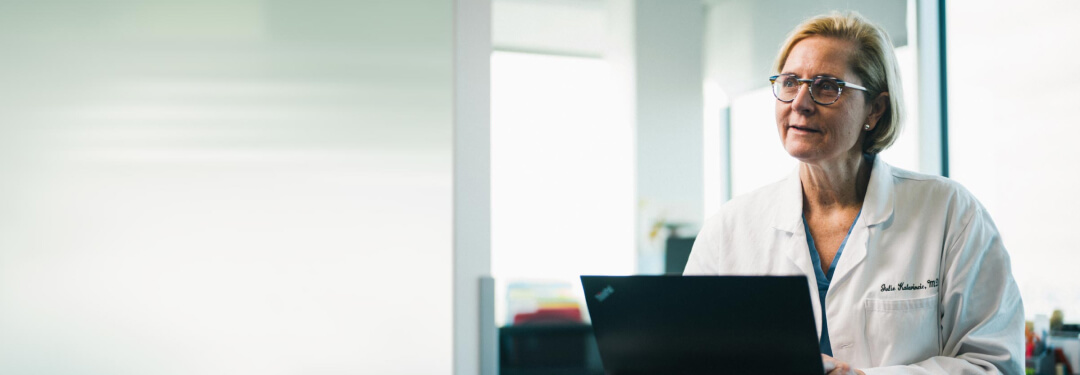 physician in white coat using apps on mobile